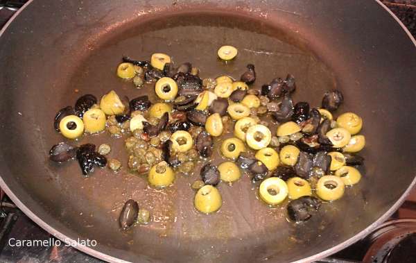 Aggiungere i capperi e le olive tagliate a rondelle e far insaporire